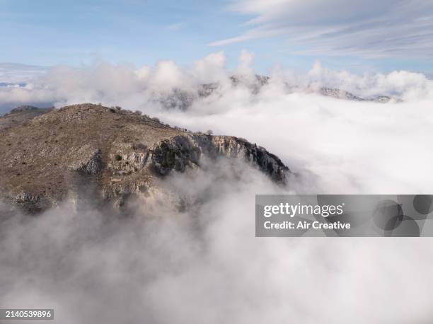 drone image of a rocky ridge surrounded by sea of clouds, alpes-maritimes, france - air france stock pictures, royalty-free photos & images