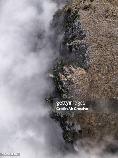 top-down aerial view showing clouds wedged by a rocky mountain ridge, alpes-maritimes, france - air france stock pictures, royalty-free photos & images