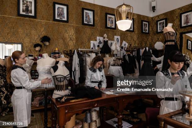 Tailors and seamstresses of the Italian fashion house Dolce & Gabbana work on haute couture outfits during the exhibition "From the Heart to the...