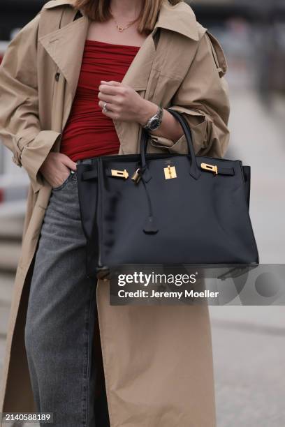 Sonia Lyson seen wearing Viveh dark red cotton top, Levi’s grey denim long straight leg pants / jeans, COS beige oversized long coat, Hermès black...