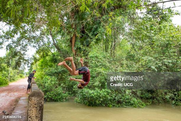 Cambodia, Kampong Phluk, children dive into the swollen river.