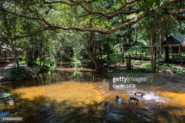 Cambodia, Kulen mountain, children swim in the swollen river.