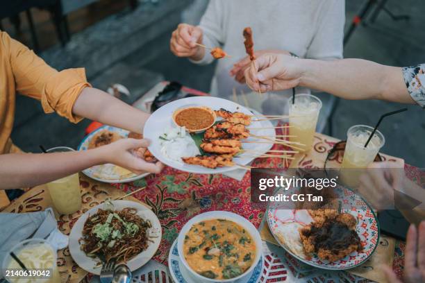 high angle view asian tourist sharing satay, malaysian food at street stall - asian food stock pictures, royalty-free photos & images