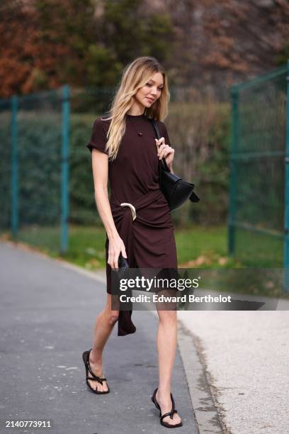 Jessie Andrews wears a brown gathered dress, a black leather bag, brown open toe sandals, outside Ferragamo, during the Milan Fashion Week -...