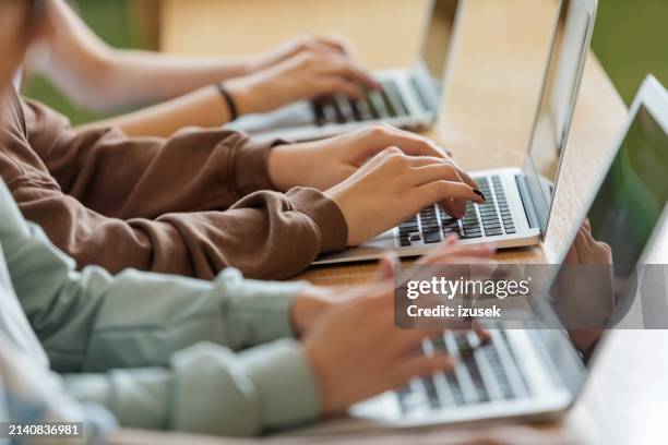 teenage girls using typing on laptops - classroom laptop stock pictures, royalty-free photos & images