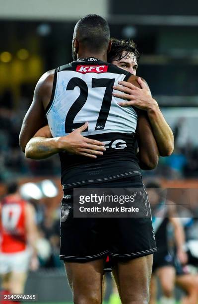 Esava Ratugolea hugs Aliir Aliir of the Power at the final siren during the round four AFL match between Port Adelaide Power and Essendon Bombers at...