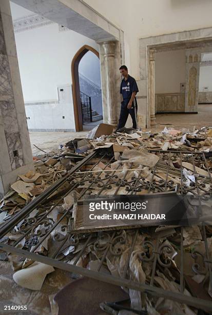 An Iraqi man walks 19 June 2003, in one of the rooms in the home of toppled leader Saddam Hussein's most trusted lieutenant, Abid Hamid Mahmud knwon...