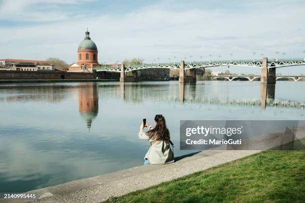 tourist woman taking a photo in toulouse - toulouse imagens e fotografias de stock