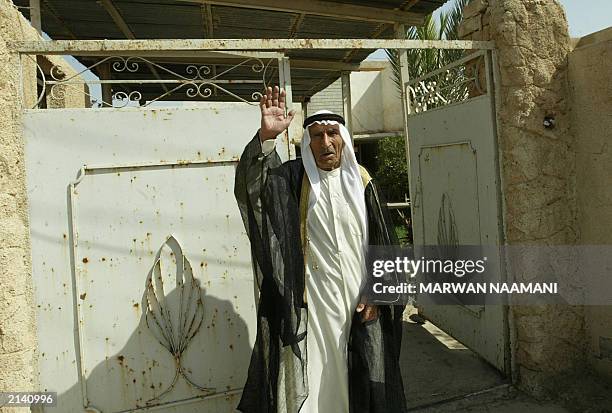 Hamid, the 80-year-old father of Abid Hamid Mahmud, the most trusted lieutenant of toppled leader Saddam Hussein, waves 19 June 2003 outside his home...