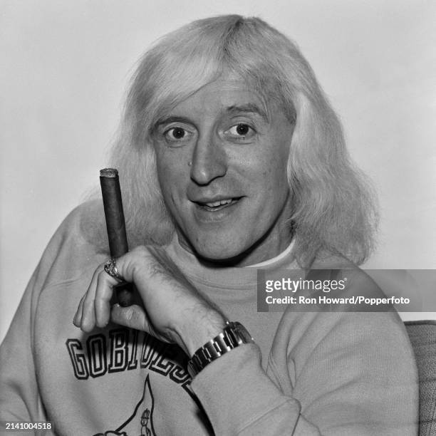 English DJ and television presenter Jimmy Savile posed with a large cigar backstage in London circa 1972.