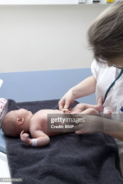 The pediatrician checks the condition of the umbilical cord.