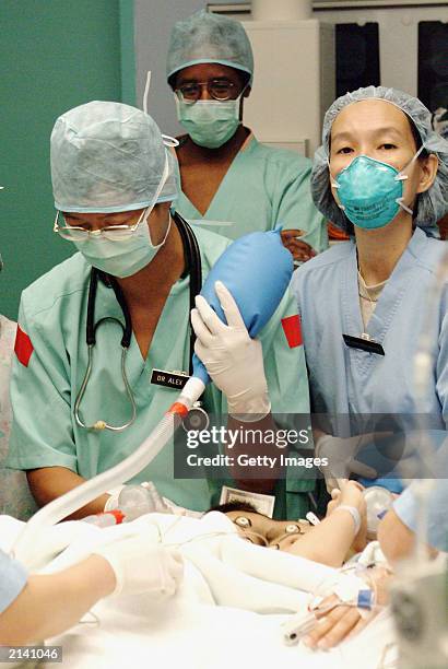 In this handout photo from Raffles Hospital, Dr. Alex Lee and Dr. Ong Biauw Chi start anaesthetic proceedings on conjoined twins Ladan and Laleh...