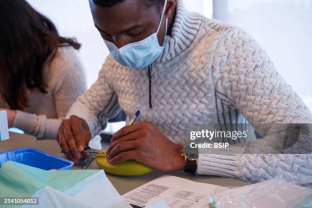 5th year students during a sewing workshop. The students learn the gestures of suturing on false epidermis or bananas.