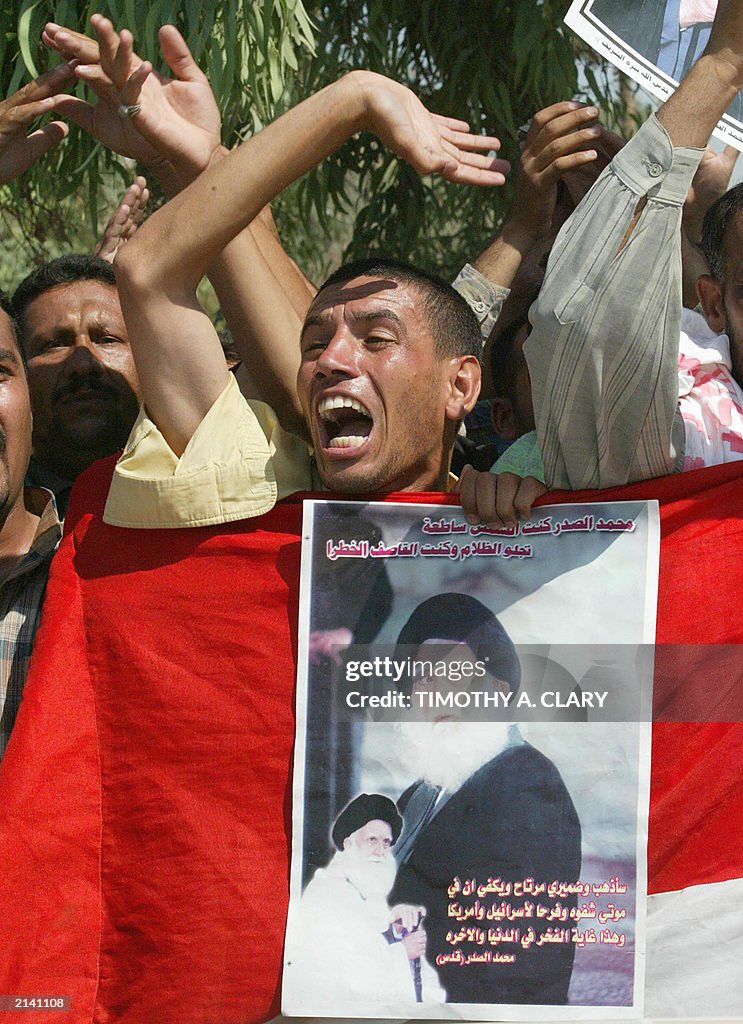An Iraqi man carrying a poster of late S
