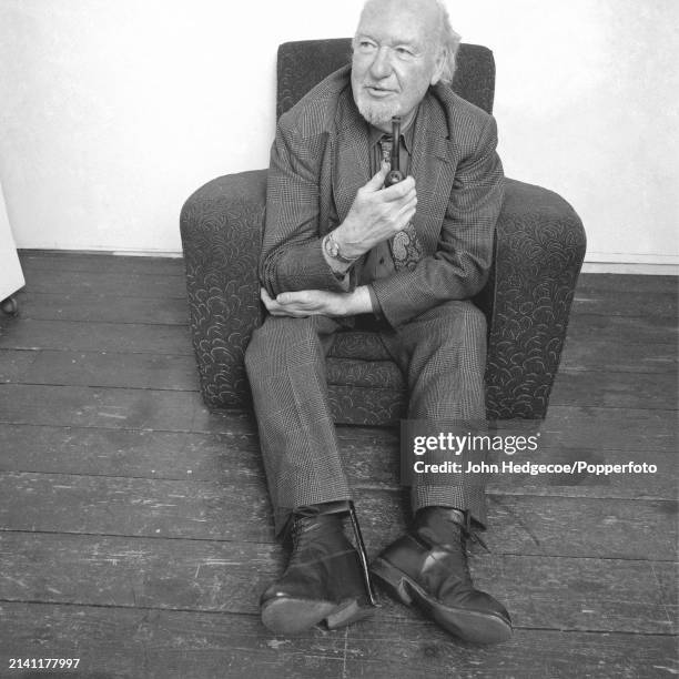 English artist and painter Ruskin Spear seated in an armchair at a Royal College of Art studio in London in 1983.