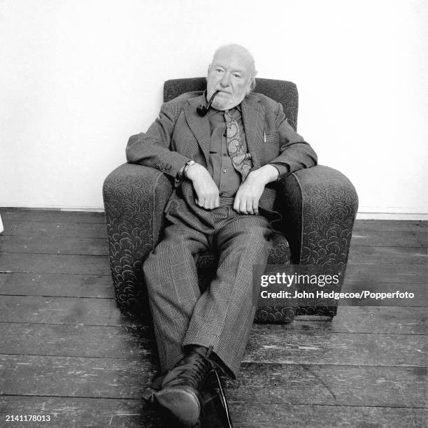 English artist and painter Ruskin Spear seated in an armchair at a Royal College of Art studio in London in 1983.