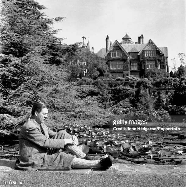 British industrialist and horticulturalist Charles McLaren, 3rd Baron Aberconway seated in the grounds of Bodnant Hall and Gardens near the village...
