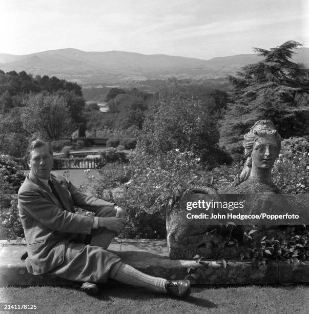 British industrialist and horticulturalist Charles McLaren, 3rd Baron Aberconway seated in the grounds of Bodnant Hall and Gardens near the village...