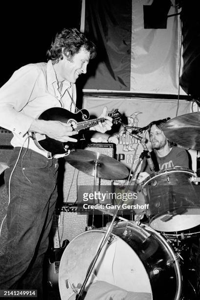 American Rock musician Levon Helm plays mandolin as he performs onstage at the Lone Star Cafe, New York, New York, February 17, 1981. Visible at rear...