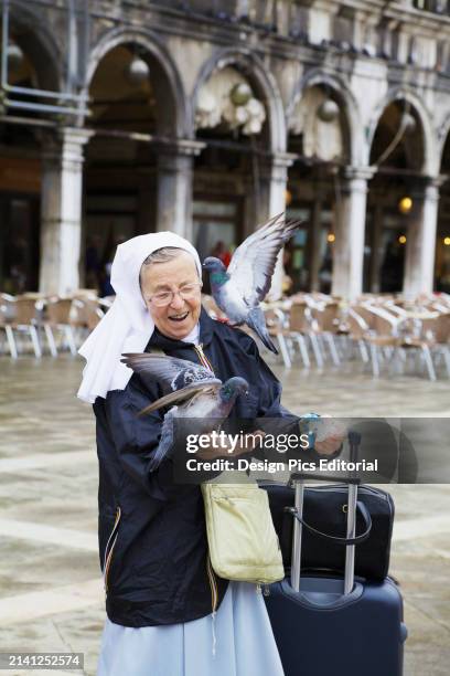 Nun Feeding Pigeons In Piazza San Marco. Venice, Veneto, Italy.