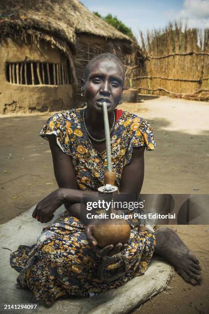 Nuer Woman Smoking Traditional Pipe, Western Ethiopia. Ethiopia.