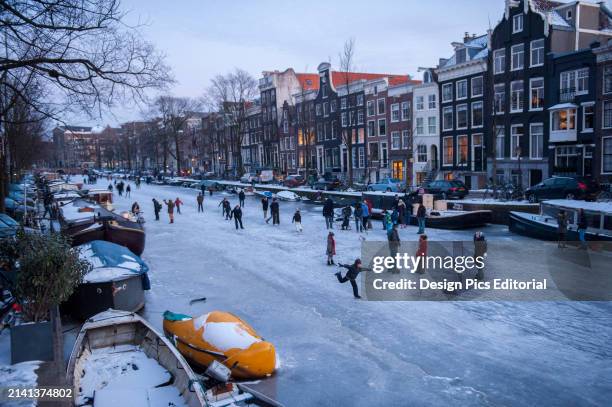 Numerous people ice skating on the canals. Amsterdam, Netherlands.