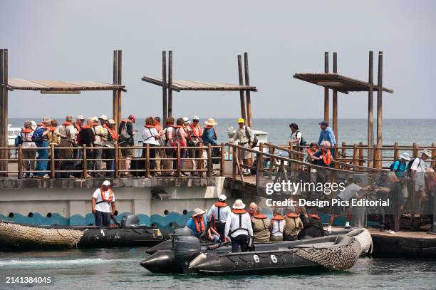 Tourists board inflatable boats on San Cristobal Island in the Galapagos, Galapagos Islands National Park. San Cristobal Island, Galapagos Islands,...