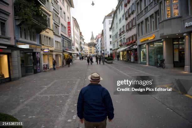 Senior man stands in the middle of a city street in Zurich, Switzerland. Zurich, Switzerland.