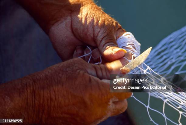 Fisherman mending a net, view of hands. Marsaxlokk, Malta Island, Republic of Malta.