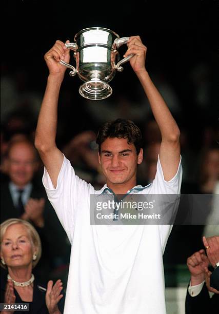 Roger Federer of Switzerland holds aloft the Boys Singles trophy after his win over Irakli Labadze of Georgia in the Boys Singles Final during The...