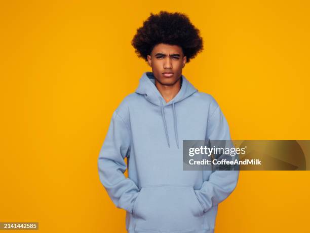 hombre afroamericano con peinado africano con sudadera con capucha de pie sobre fondo amarillo aislado - camisa con capucha fotografías e imágenes de stock
