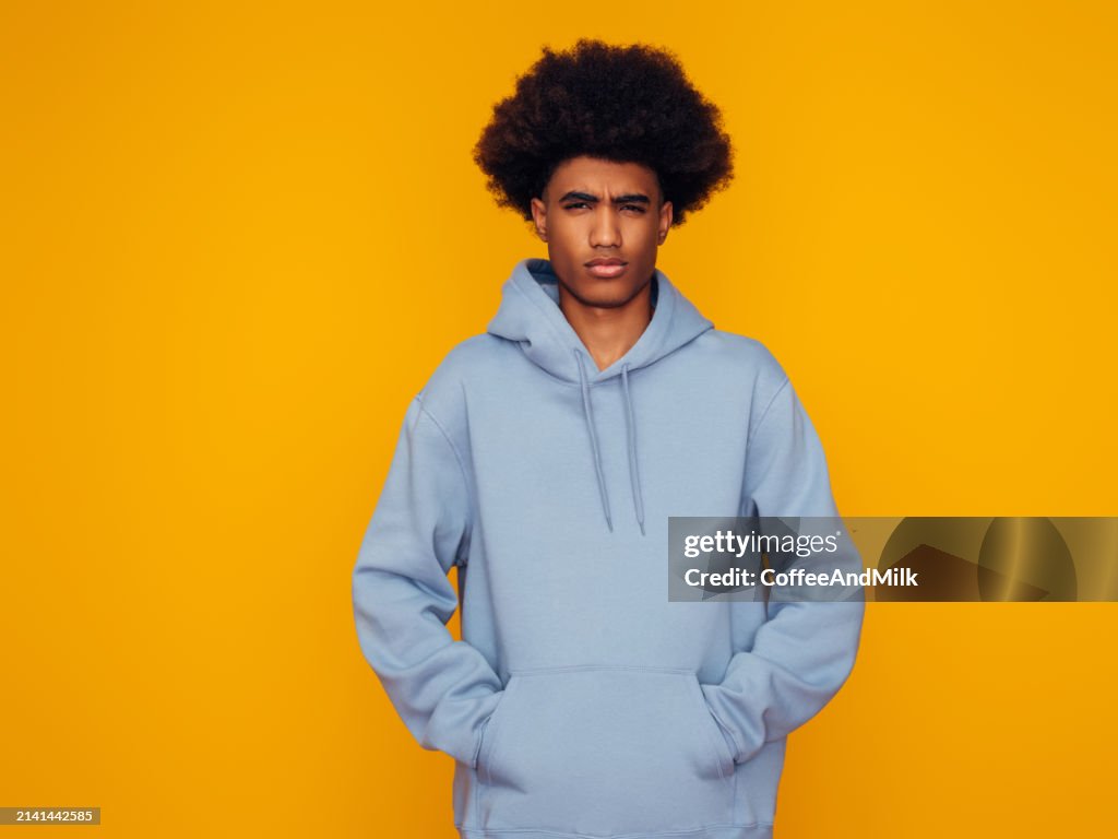 African american man with african hairstyle wearing hoodie standing over isolated yellow background