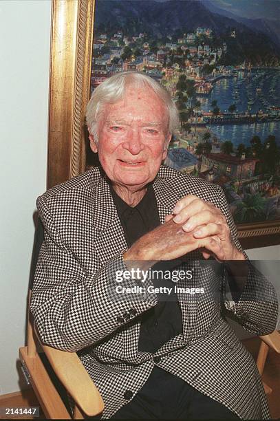 Actor Buddy Ebsen sits in front of his artwork displayed at a Beverly Hills art gallery August 26, 2000 in Beverly Hills, California. The paintings...