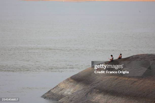 Boys fish at the Orinoco River on April 05, 2024 in Puerto Carreño, Colombia. Puerto Carreño is the departmental capital city, and a municipality...