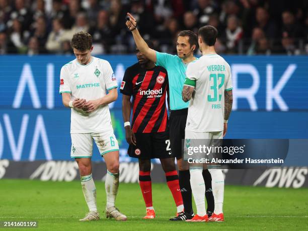 Referee Robert Hartmann gestures as Jens Stage of SV Werder Bremen reacts after being shown a red card during the Bundesliga match between Eintracht...