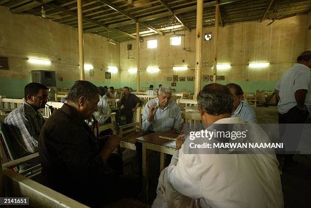 Iraqi men play a game of dominos at the Al-Mustansiriyah coffee shop in central Baghdad 22 June 2003. The coffee shop was built in 1587 and housed...