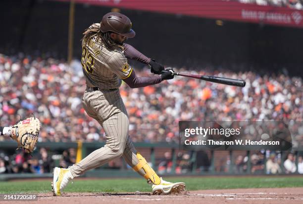 Fernando Tatis Jr. #23 of the San Diego Padres hits an RBI single scoring Jackson Merrill against the San Francisco Giants in the top of the third...