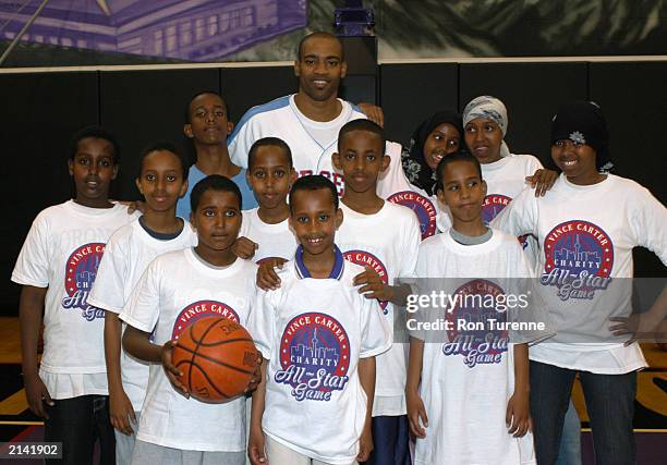 Vince Carter of the Toronto Raptors poses with children during a practice session for the Vince Carter Charity All Star Game in Toronto, Ontario....