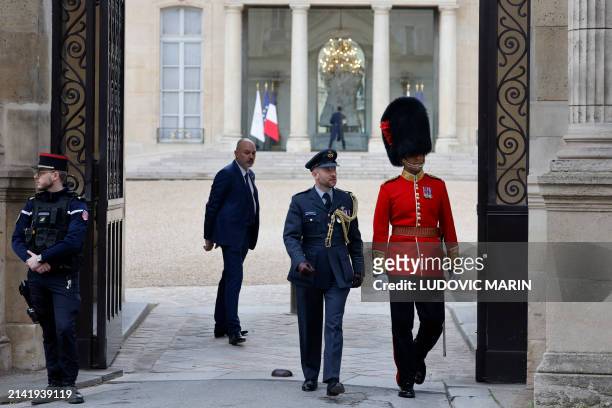 British member of the Number 7 Company Coldstream Guards walks along side a member of the French military through the gates of the Elysee Palace, in...