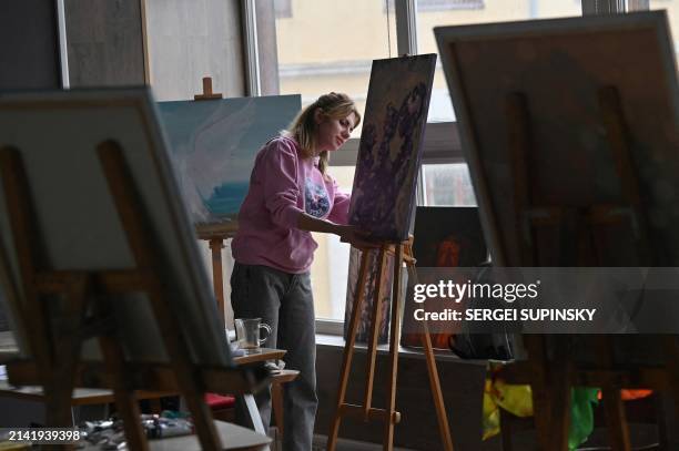 Woman poses during an art therapy workshop titled "Live" and organised by the "Modern Ukraine" Charitable Foundation for women who lost their...