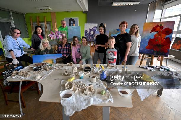 Women and their children pose during an art therapy workshop titled "Live" and organised by the "Modern Ukraine" Charitable Foundation for women who...