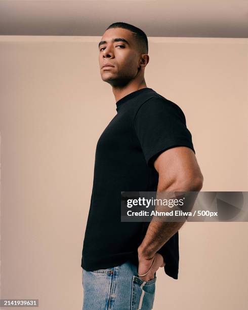 portrait of young man standing against wall - editorial stock pictures, royalty-free photos & images