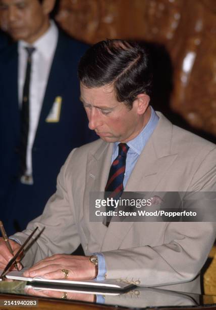 Prince Charles signing a visitor book in Jakarta, Indonesia during a four-day visit to the country, on 6th November, 1989.