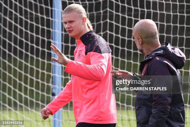 Manchester City's Norwegian striker Erling Haaland talks to Manchester City's Spanish manager Pep Guardiola during a training session on the eve of...