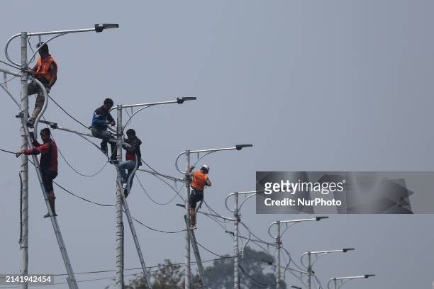 Nepali workers are fitting electric street lamps on the streets of Kathmandu, Nepal, on April 8, 2024.