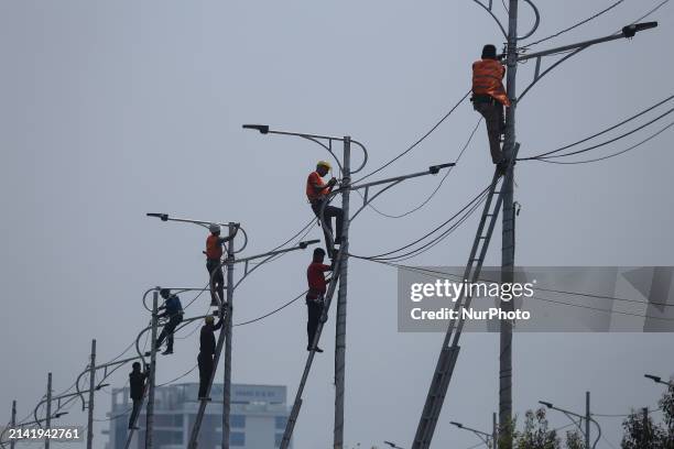 Nepali workers are fitting electric street lamps on the streets of Kathmandu, Nepal, on April 8, 2024.