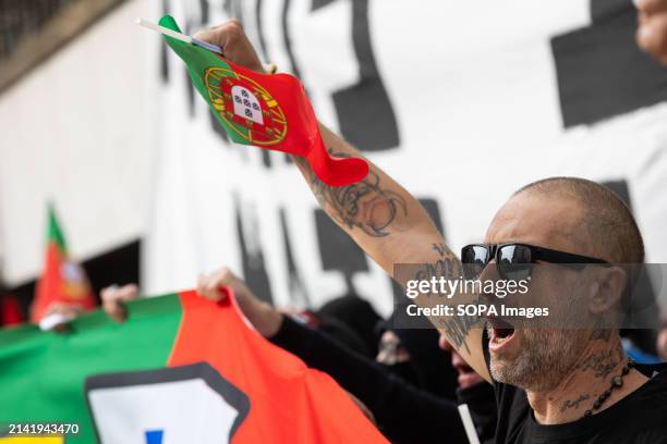 An anti-immigration sympathizer holds a Portugal flag during a far-right protest in the streets of Porto Around two hundred far-right protesters...
