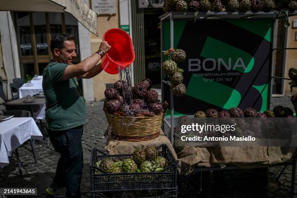 Man washes fresh Roman artichokes in a restaurant at the Jewish quarter during the inauguration of the Festival of the Roman Artichoke , on April 8...