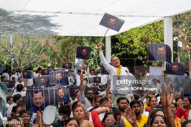 Aam Aadmi Party supporters chant slogans and hold Posters depicting Delhi chief Minister Arvind Kejriwal behind bars, a symbolic representation...