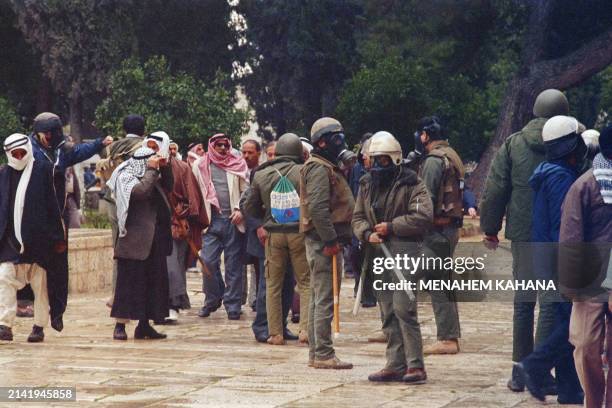 Israeli riot policemen control Palestinians on January 15, 1988 following the Friday midday prayer on the Temple Mount in East Jerusalem. Clashes...